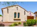 Charming single-story home highlighting arched windows, manicured landscaping, and a secure home monitoring system at 20962 W Thomas Rd, Buckeye, AZ 85396