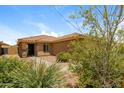 Landscaped front yard with desert plants leading to the front door and tiled roof at 23162 W Lasso Ln, Buckeye, AZ 85326