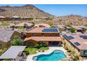 Expansive aerial view of property featuring a backyard swimming pool with desert landscaping and solar panels at 27809 N Silverado Ranch Rd, Peoria, AZ 85383