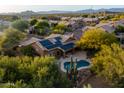 Expansive aerial view of home featuring solar panels, sparkling pool, and lush desert landscaping at 28897 N 94Th Pl, Scottsdale, AZ 85262