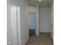 Bright hallway featuring tile flooring, white walls, and multiple doorways, offering a clean and modern feel at 30918 W Mulberry W Dr, Buckeye, AZ 85396