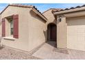 Inviting home entrance featuring an arched doorway, red front door, and a two-car garage at 32567 N 133Rd Ave, Peoria, AZ 85383
