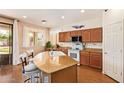 Well-lit kitchen featuring a granite island with seating, white appliances, and sliding door access to backyard at 3381 E Canary Way, Chandler, AZ 85286