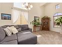 Bright living room with vaulted ceilings, plush gray sofa, decorative pillows, and large windows with sheer curtains at 3381 E Canary Way, Chandler, AZ 85286