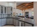 Stylish kitchen featuring gray cabinetry, modern countertops, and an open floor plan into the living area at 3405 E Knox Rd, Phoenix, AZ 85044