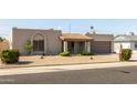 Single-story home boasting mature landscaping and a neutral color scheme at 3821 W Woodridge Dr, Glendale, AZ 85308