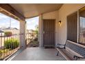 Inviting covered front porch with a security door, seating and desert landscaping at 3821 W Woodridge Dr, Glendale, AZ 85308