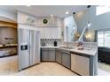 Well-lit kitchen featuring stainless steel appliances, sleek countertops, and modern backsplash at 4328 W Judson Dr, New River, AZ 85087