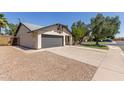 Side view of a single-story home with a gray garage door and desert landscaping at 45 S Rita Ln, Chandler, AZ 85226