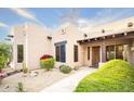 Exterior elevation showcasing a beige stucco home with desert landscaping and a welcoming walkway at 5520 E Desert Forest Trl, Cave Creek, AZ 85331