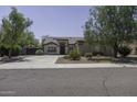 Charming single-story home with desert landscaping and mature trees, featuring a neutral color scheme at 651 W Cobblestone Dr, Casa Grande, AZ 85122