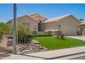 Landscaped front yard with artificial turf, stone accents, and desert plants at 9563 E Keats Ave, Mesa, AZ 85209