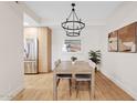 Cozy dining room with modern light fixture, wood table set, and an open view into the kitchen at 9708 E Via Linda Rd # 1350, Scottsdale, AZ 85258