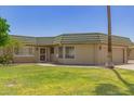 Inviting front entrance featuring a secure screen door and manicured lawn at 10505 W Campana Dr, Sun City, AZ 85351