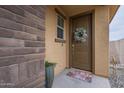 Inviting front entrance with a decorative wreath, welcome mat, and a stone accent wall at 11470 E Yeager Cyn, Gold Canyon, AZ 85118