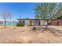 Single-story home featuring a yellow front door and a low maintenance desert landscape at 12453 N 29Th Ave, Phoenix, AZ 85029