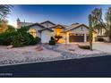 Single-story home boasting a three-car garage, desert landscaping, and a driveway with ample parking at 12754 E Laurel Ln, Scottsdale, AZ 85259