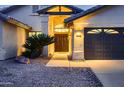 Inviting home featuring a double-door entrance and three-car garage, enhanced by desert landscaping at 12754 E Laurel Ln, Scottsdale, AZ 85259