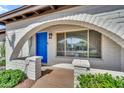 Close-up of arched entryway with a blue door, neutral brick, and desert landscaping at 12826 N 29Th St, Phoenix, AZ 85032
