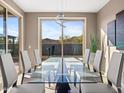 Dining room featuring a glass table, modern lighting fixture and desert views at 13406 W Rowel Rd, Peoria, AZ 85383