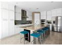 Gourmet kitchen with white cabinetry, an island with seating, and stainless steel appliances at 13406 W Rowel Rd, Peoria, AZ 85383