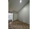 Empty bedroom boasts tile flooring, a window overlooking green trees, and a double-door closet at 14002 N 49Th Ave # 1120, Glendale, AZ 85306