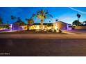 Stunning home exterior at dusk with desert landscaping, dramatic lighting, and a spacious three car garage at 14014 N 57Th Way, Scottsdale, AZ 85254