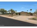 Beautiful single-story home showcasing desert landscaping, a spacious three car garage, and a well maintained lawn at 14014 N 57Th Way, Scottsdale, AZ 85254