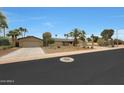Charming single-story home featuring a neutral color palette, desert landscaping, and a spacious three car garage at 14014 N 57Th Way, Scottsdale, AZ 85254