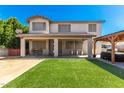 Home's backyard features playground, covered patio, and lush artificial grass at 14604 W Banff Ln, Surprise, AZ 85379