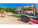 Enjoy outdoor living in this backyard with a patio, artificial grass, and playground at 14604 W Banff Ln, Surprise, AZ 85379