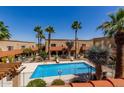 Community pool surrounded by palm trees and desert landscaping at 16336 E Palisades Blvd # 4, Fountain Hills, AZ 85268