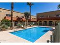 Community pool surrounded by well-manicured landscaping and multiple palm trees at 16336 E Palisades Blvd # 4, Fountain Hills, AZ 85268