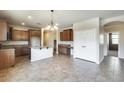 Open-concept kitchen and dining area with tile flooring, ample cabinet space, and modern lighting at 17789 W Bridger St, Surprise, AZ 85388