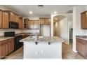 Well-lit kitchen featuring granite countertops, a kitchen island, and plenty of cabinet space at 17789 W Bridger St, Surprise, AZ 85388