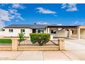 Ranch-style house with a covered parking area, gravel front yard, and black iron fence at 1852 N Grand St, Mesa, AZ 85201