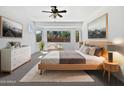Comfortable main bedroom with a bay window, ceiling fan, and neutral colored walls at 19973 E Thornton Rd, Queen Creek, AZ 85142