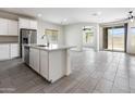 Bright, airy living space featuring tile floors, island, and a stainless steel dishwasher overlooking an additional sitting area at 2181 N 211Th Dr, Buckeye, AZ 85396