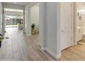 Bright hallway with wood-look tile, leading to an open living area and a bathroom at 24314 N 21St Pl, Phoenix, AZ 85024