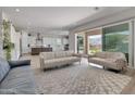 Open-concept living room with light-colored sofas, seamless transition to the kitchen and outdoor views at 24314 N 21St Pl, Phoenix, AZ 85024