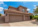 Spacious three-car garage with a tile roof and neutral stucco, providing ample parking and storage space at 3514 E Desert Broom E Way, Phoenix, AZ 85044
