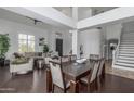 Open-concept living and dining area featuring high ceilings, dark wood floors and a modern staircase at 3514 E Desert Broom E Way, Phoenix, AZ 85044