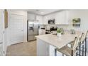Modern kitchen with white cabinetry, stainless steel appliances, and a quartz countertop island at 36620 W Maddaloni Ave, Maricopa, AZ 85138