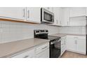 Modern kitchen featuring white cabinets, stainless steel appliances, and light countertops at 3913 S 233Rd Ln, Buckeye, AZ 85326