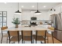 A modern kitchen featuring a central island with seating and stainless steel appliances at 3913 S 233Rd Ln, Buckeye, AZ 85326