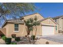 Tan single story home with an attached garage and landscaped front yard with stone and plants at 4514 W Hazel Ln, San Tan Valley, AZ 85144