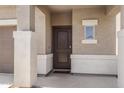 Covered front porch area featuring decorative columns and a dark wood front door with sidelight at 4527 E Gagarinite Ln, San Tan Valley, AZ 85143