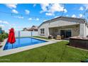 Inviting backyard featuring a sparkling pool, spa, and comfortable patio seating under string lights at 5341 W Alta Mesa Ave, Laveen, AZ 85339