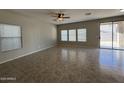 Bright living room with tile floors, large windows with privacy blinds, and sliding glass door leading to outdoor area at 6341 W Valencia Dr, Laveen, AZ 85339