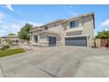 Side view of a two-story home highlighting the 3-car garage, and manicured lawn at 7129 S Stadium Way, Gilbert, AZ 85298